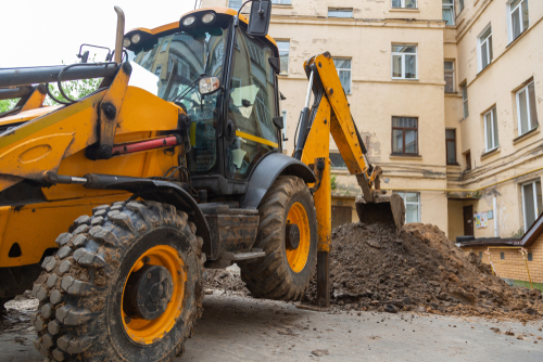 Excavator,digs,a,trench.,repair,work,in,the,courtyard,of