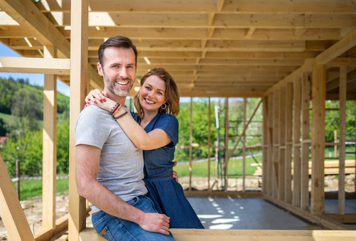 Couple,standing,on,future,window,in,construction,site,of,their
